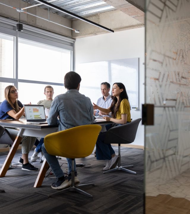 Group of business people talking in a meeting at the office Group of Latin American business people talking in a meeting at the office